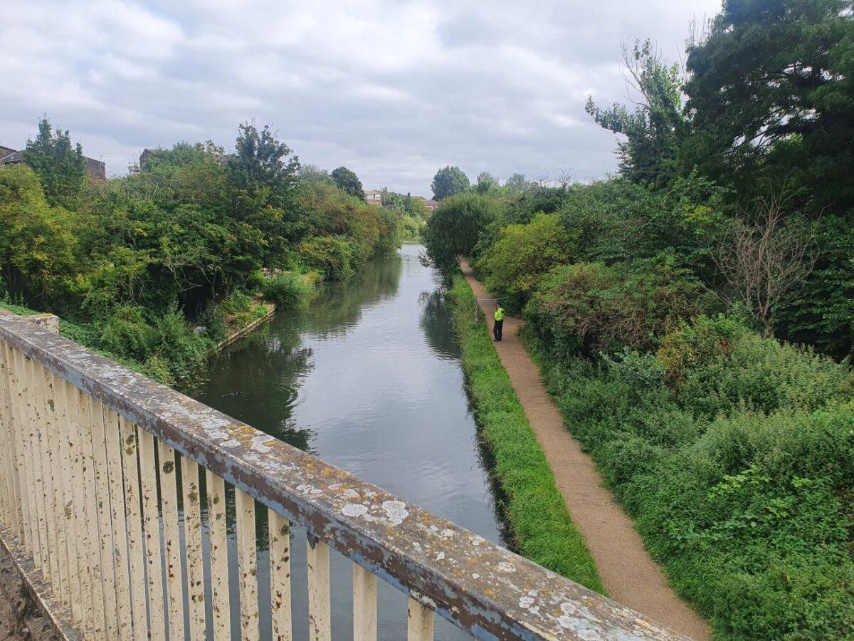A police officer patrolling the towpath close to where Lee Peacock was arrested, on a barge on the Grand Union Canal in Greenford, west London, on Aug. 25, 2021. (Chris Summers/The Epoch Times)