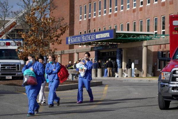 Medical staff walk away from an entrance to Signature Healthcare Brockton Hospital in Brockton, Mass., on Feb. 7, 2023. (Steven Senne/AP Photo)