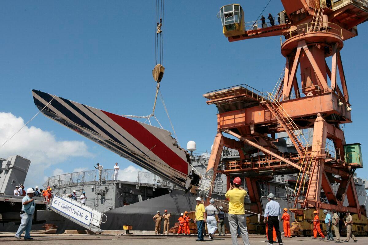 Workers unload debris, belonging to the crashed Air France flight AF447, from the Brazilian Navy's Constitution Frigate in the port of Recife, northeast of Brazil, on June 14, 2009. (Eraldo Peres/AP Photo)