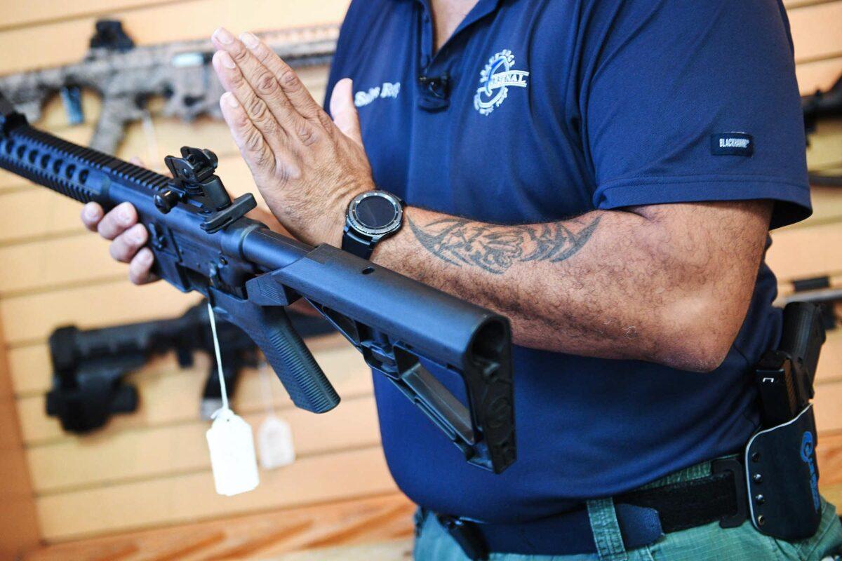 Senior Sales Staff Mark Warner shows a bump stock installed on an AR-15 rifle at Blue Ridge Arsenal in Chantilly, Va., on Oct. 6, 2017. (Jim Watson/AFP/Getty Images)