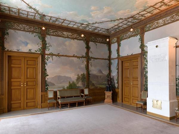 The Bird Room's decoration, completed in 1843 by Johannes Flintoe, features a variety of Norwegian birds perched on what looks like an open garden pavilion. Reflecting the 19th-century interest in Norwegian history and nature, the wall and ceiling paintings represent Norway’s beautiful scenery and its native birds and butterflies. The room’s furniture, dating to 1846, is made of oak in the Neo-Renaissance style. (The Royal Court)