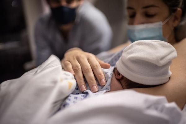 A father and a mother look at their newborn son at the maternity of the Diaconesses hospital in Paris, on Nov. 17, 2020. (Martin Bureau/AFP via Getty Images)