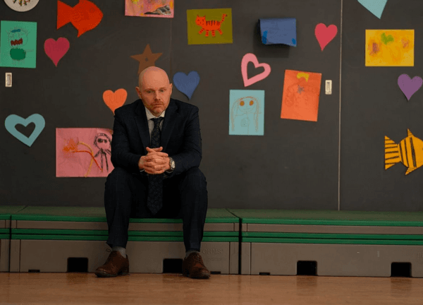 Jack Kelly (Bill Burr) waiting to apologize to the entire school for calling the principal a very, very bad name, in "Old Dads." (Netflix)