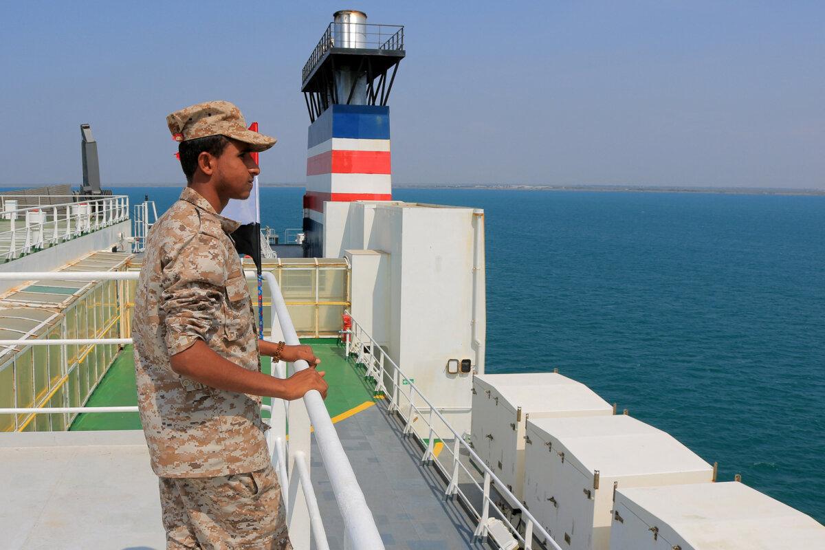 A picture taken during an organized tour by Yemen's Houthis shows a security guard aboard the Galaxy Leader cargo ship, seized by Houthi fighters two days earlier, in a port on the Red Sea in the Yemeni province of Hodeida, with Palestinian and Yemeni flags installed on it, on Nov. 22, 2023. (AFP via Getty Images)