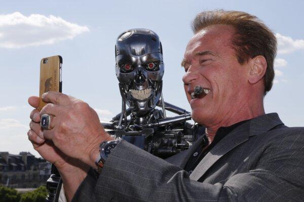 U.S. actor and former Governor of California Arnold Schwarzenegger takes a selfie photo with the "Terminator" animatronics robot during a photo call for the film "Terminator Genisys" in Paris on June 19, 2015. (Francois Guillot/AFP via Getty Images)