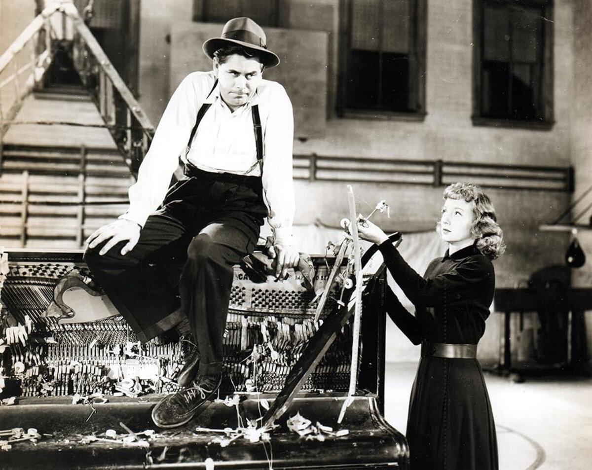Joe Miracle (Glenn Ford) has fallen onto a piano and Jenny Jones (Evelyn Keyes) reprimands him, in “Mr. Soft Touch.” (Columbia Pictures)