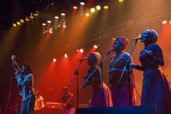 (L–R) Bob Marley (Kingsley Ben-Adir) and his backup singers, The I-Threes: Judy Mowatt (Anna Share-Blake), Rita Marley (Lashana Lynch), and Marcia Griffiths (Naomi Cowan), in "Bob Marley: One Love." (Paramount Pictures)