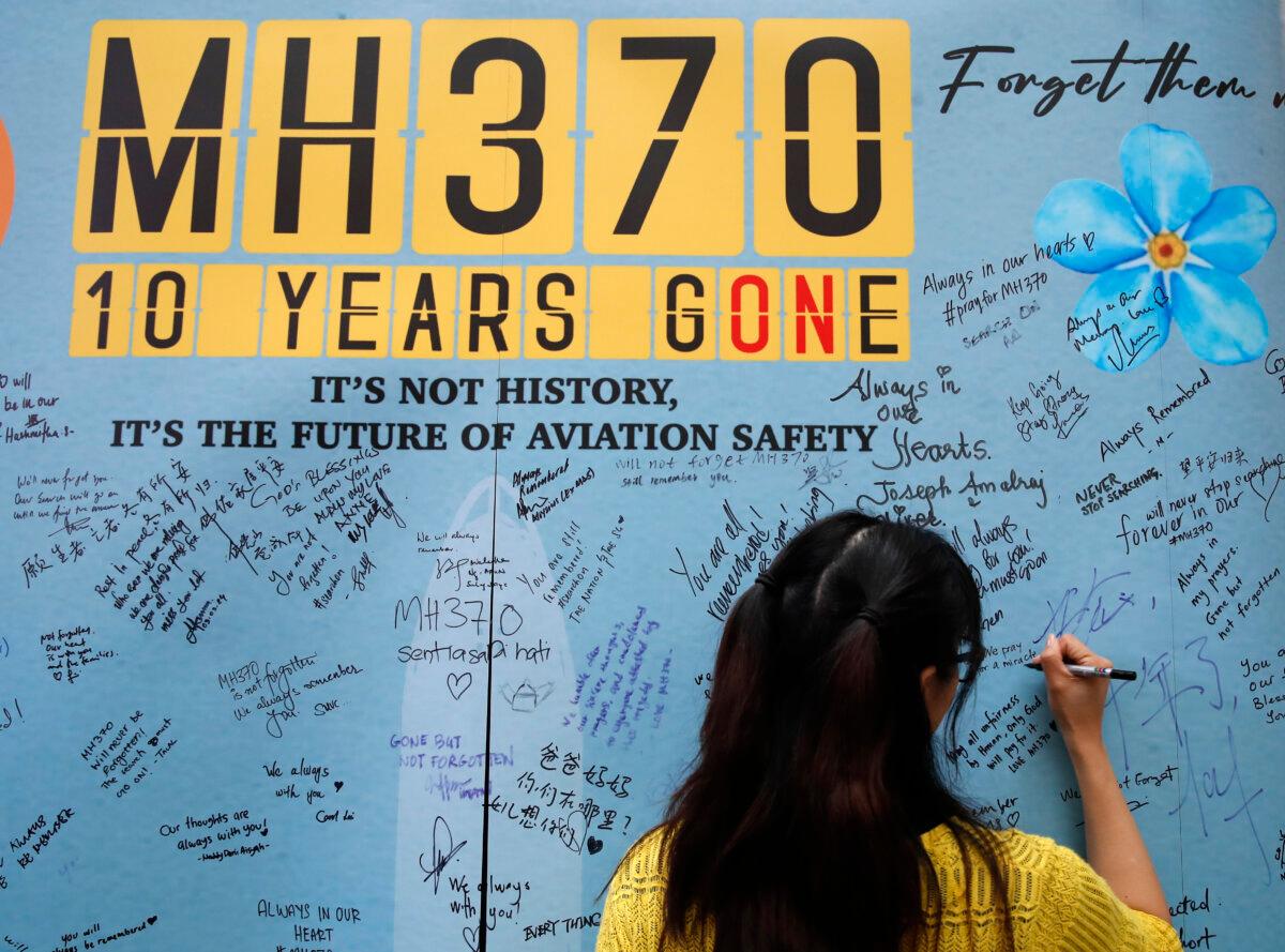 A woman writes well messages on the message board during the tenth annual remembrance event at a shopping mall in Subang Jaya, on the outskirts of Kuala Lumpur, Malaysia, on March 3, 2024. (FL Wong/AP Photo)