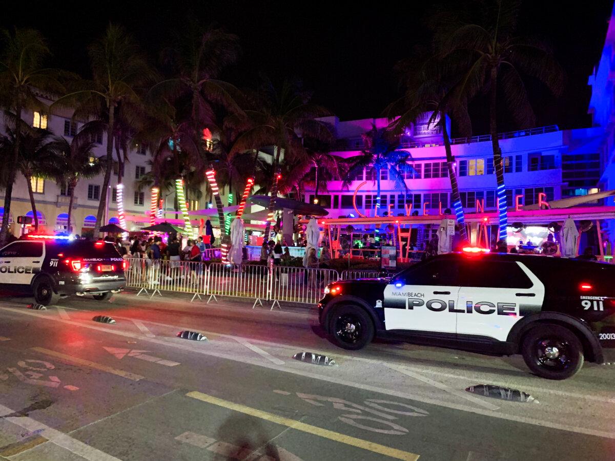 Miami Beach Police cars drive past The Clevelander Hotel and Club in Miami Beach, Fla., on March 14, 2024. (T.J. Muscaro/The Epoch Times)