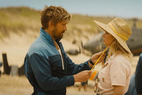 Stuntman Colt Seavers (Ryan Gosling) adjusts camerawoman Jody Moreno's (Emily Blunt) sun hat, in "The Fall Guy." (Universal Pictures)