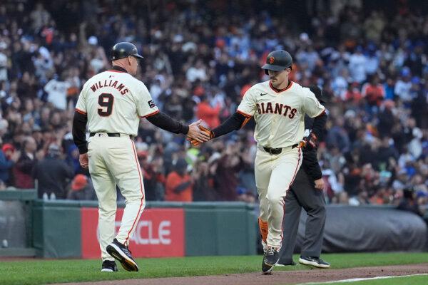 Mike Yastrzemski receives a hand slap from Giants third-base coach Matt Williams after hitting a home run against the Dodgers in San Francisco on May 15, 2024. (Jeff Chiu/AP Photo)