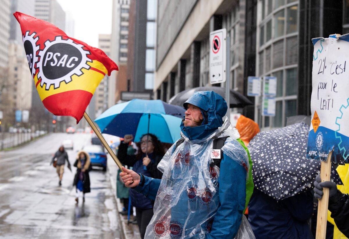 Public Service Alliance of Canada workers from the Canada Revenue Agency stand on the picket line in Montreal during a nationwide strike, on May 1, 2023. (The Canadian Press/Christinne Muschi)