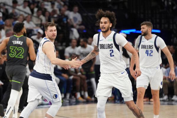 Dereck Lively II of the Mavericks receives a hand slap from teammate Luka Doncic during Game 5 of the NBA Western Conference finals against the Timberwolves in Minneapolis on May 30, 2024. (Abbie Parr/AP Photo)