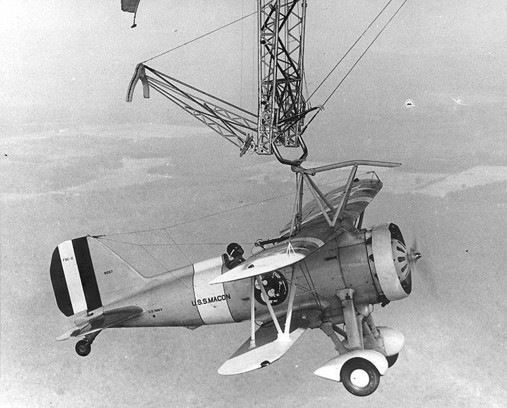 The F9C-2 Sparrowhawk fighter shown hanging from the trapeze of the airship USS Macon. (Public Domain)