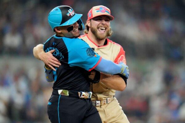 American League starting pitcher Corbin Burnes (R) of the Baltimore Orioles and his former Milwaukee Brewers battery mate, National League catcher William Contreras, clown around after a first-inning play in the All-Star Game in Arlington, Texas, on July 16, 2024. (Julio Cortez/AP Photo)