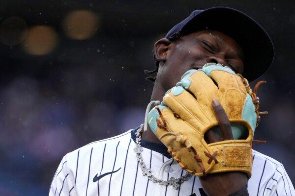 Jazz Chisholm Jr. covers his face with his glove while talking to Yankees teammates during a game against the Angels in New York on Aug. 7, 2024. (Pamela Smith/AP Photo)