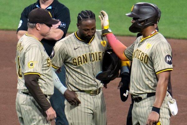 Padres All-Star left fielder Jurickson Profar, flanked by Manager Mike Shildt (L) and teammate Xander Bogaerts, leaves a game against the Pirates after being hit by a pitch in Pittsburgh on Aug. 7, 2024. (Gene J. Puskar/AP Photo)