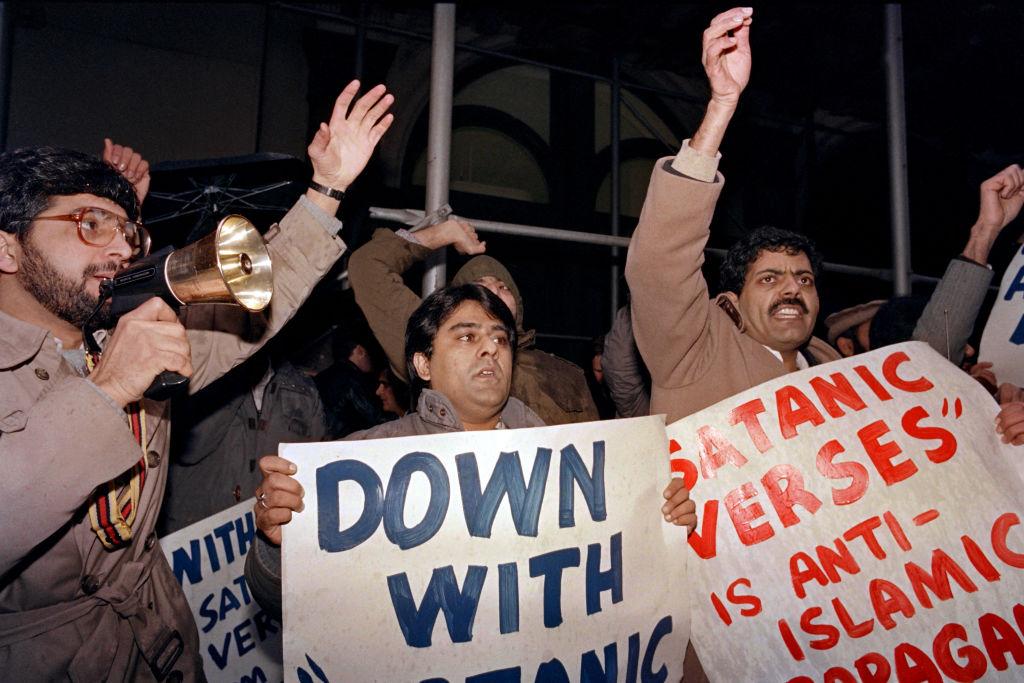 Hundreds of Muslims gather outside the site of a reading of the "Satanic Verses" in 1989 in New York to protest the book of Indian-born British writer Salman Rushdie, accused of blasphemy. (Ron Haviv/AFP via Getty Images)