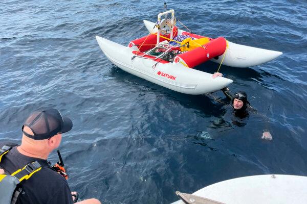 Jim Dreyer, (R), talks to his support team in Lake Michigan, on Aug. 8, 2024, on the third day of his attempt to swim from Michigan to Wisconsin. (Jonathan Boeve via AP)