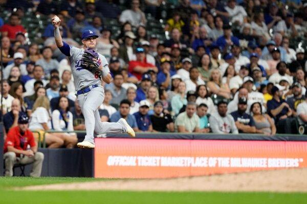 Dodgers third baseman Kiké Hernández jumps after fielding a ground ball against the Brewers in Milwaukee on Aug. 13, 2024. (Aaron Gash/AP Photo)