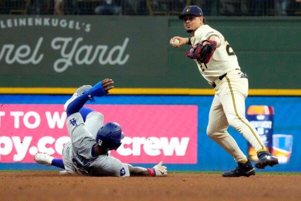 Brewers shortstop Willy Adames avoids Dodgers baserunner Jason Heyward while turning a double play in Milwaukee on Aug. 15, 2024. (Kayla Wolf/AP Photo)