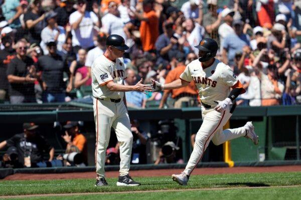 The Giants' Casey Schmitt (R) receives a hand slap from third- base coach Matt Williams after hitting a two-run home run against the Braves in San Francisco on Aug. 15, 2024. (Godofredo A. Vásquez/AP Photo)