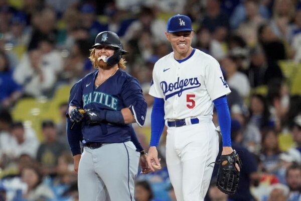 Former Dodger Justin Turner of the Mariners, in his first game back in Los Angeles, jokes with Dodgers first baseman Freddie Freeman on Aug. 19, 2024. (Marcio Jose Sanchez/AP Photo)
