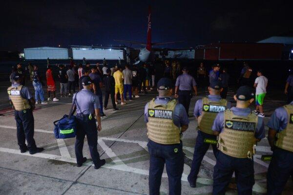 Panamanian immigration agents watch as illegal immigrants from Colombia prepare to enter a plane as they are deported from Marcos A. Gelabert de Albrook Airport in Panama City, Panama, on Aug. 20, 2024. (Agustin Herrera/AP Photo)