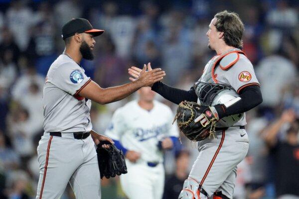 Orioles relief pitcher Seranthony Domínguez (L) celebrates with catcher Adley Rutschman after closing a victory over the Dodgers in Los Angeles on Aug. 27, 2024. (Marcio Jose Sanchez/AP Photo)