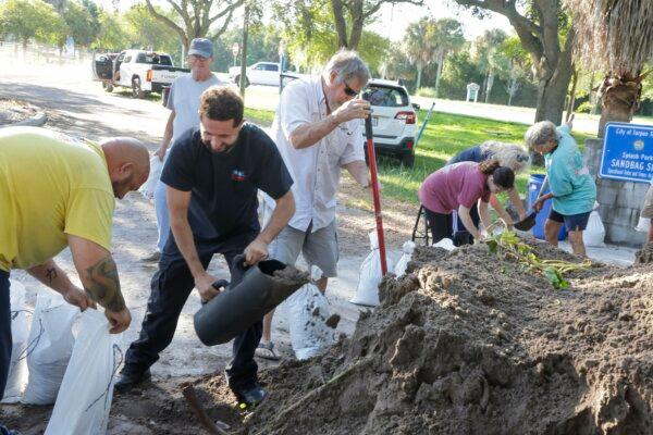 Sandbags are filled at a public site while residents prepare their homes for potential flooding in Tarpon Springs, Fla., on Sept. 24, 2024. (Douglas R. Clifford/Tampa Bay Times via AP)