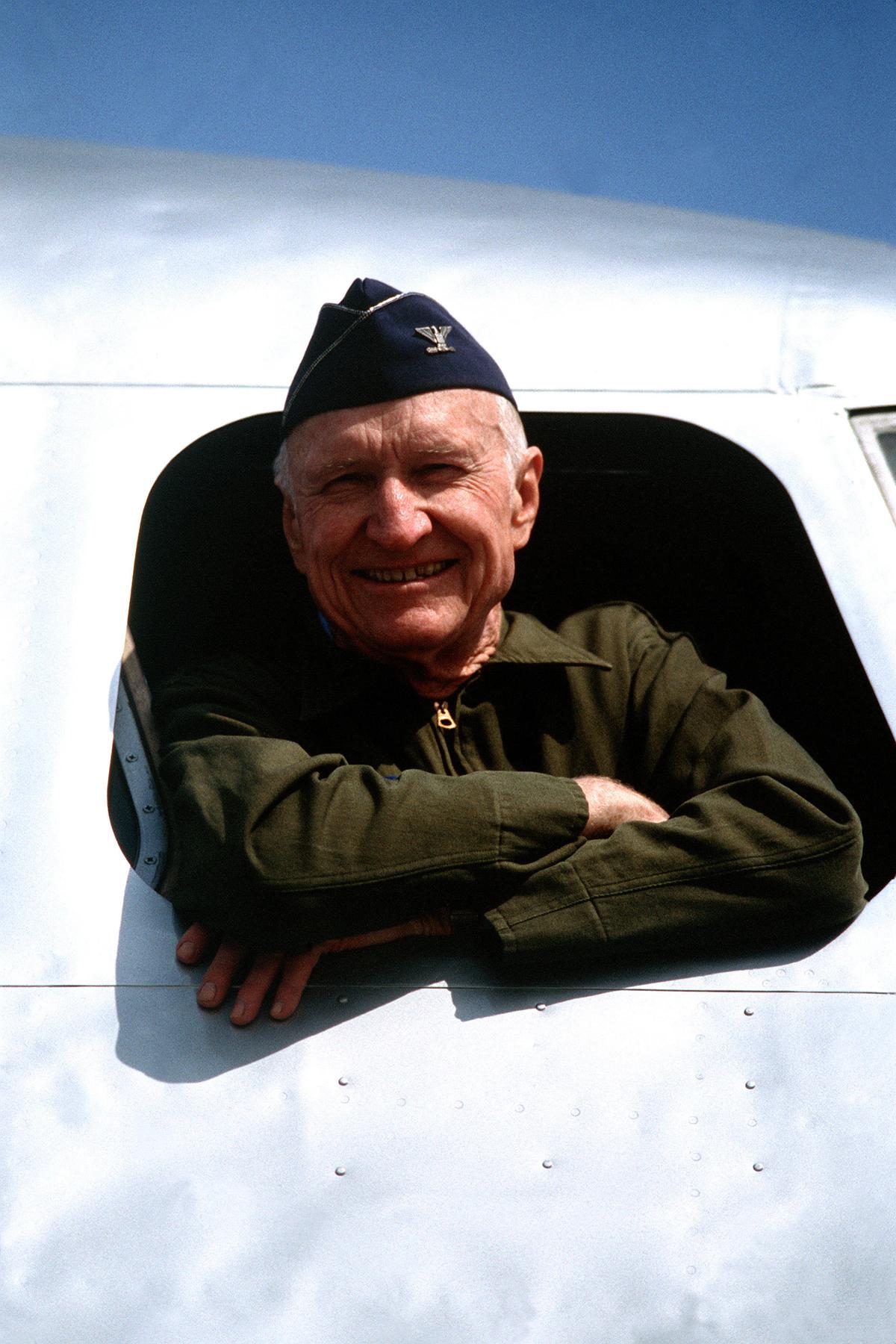Col. Gail S. Halvorsen leans out the window of a C-54 Skymaster aircraft on static display at Tempelhof Central Airport during ceremonies commemorating the 40th anniversary of the airlift, which led to the Soviet's ending the Berlin blockade. (Public Domain)