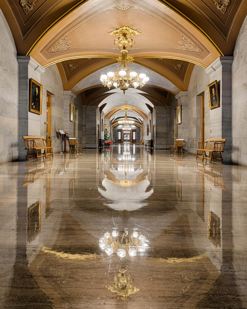 French bronze gasoliers with glass globes are the focal point of the Capitol’s expansive second-floor corridor; they hang from gilded medallions set in an intricate ceiling design. The walls are sheathed in Tennessee limestone set with carved floor-to-ceiling columns. Spaced symmetrically between doors, the columns impart a grand hall feel to this space. (Nagel Photography/Shutterstock)