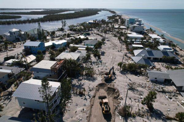 Charlotte County workers clear feet of sand from the main road on southern Manasota Key, in Englewood, Fla., following the passage of Hurricane Milton, on Oct. 13, 2024. (Rebecca Blackwell/AP Photo)