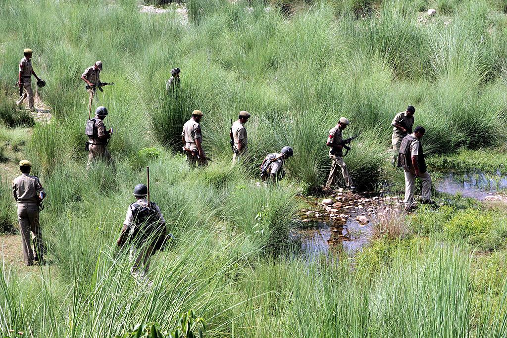 Indian security personnel walk through thick grass during a search operation for terrorists in Diyalachak, near Hiranagar village in the Kathua district, some 70 km from Jammu city on Sept. 28, 2013. In recent months, this stretch of the border has become very active with several reported incidents of infiltration, cross-border tunnels being unearthed, and narcotics and arms being dropped through drones. (STR/AFP via Getty Images)