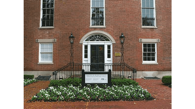Rosettes carved in stone above windows flank Decatur House’s entrance. Over the entryway’s French lited (clear glass) doors with sidelights is a fanlight pediment window topped with a band of carved stone molding. A wrought iron railing in front of the double-approach is topped with two decorative wrought iron columns and lanterns, adding to the symmetry of the façade’s design. Framing the entryway garden and stairs is a red-brick walkway laid in a basketweave pattern. (Photography by Bruce White)