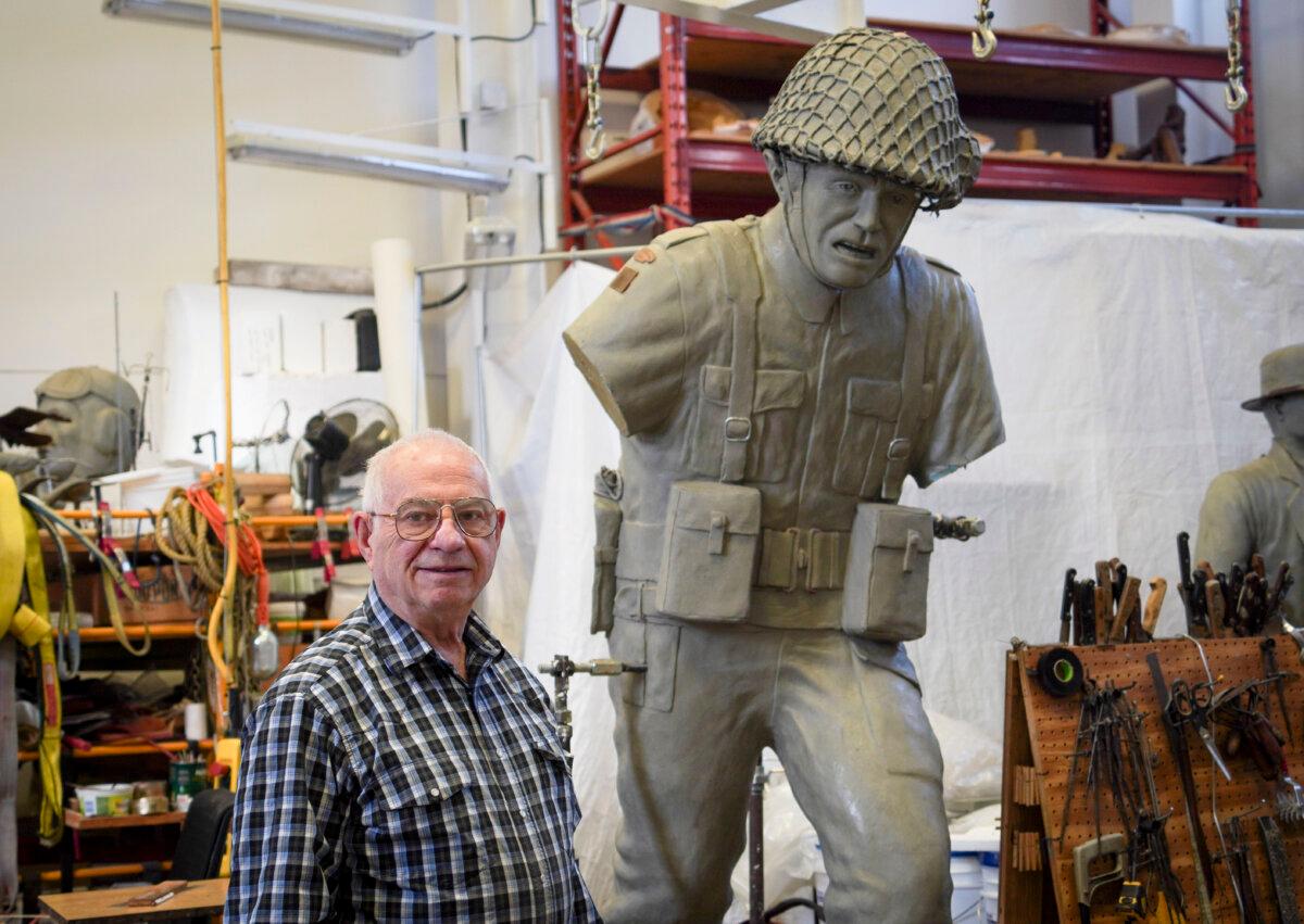 Bronze sculptor Don Begg at Studio West's workshop in Cochrane, Alta., on Nov. 22, 2024. Next to him is a clay version of a sculpture he carved of a Regina Rifles soldier to commemorate the 80th anniversary of D-Day. The original bronze sculpture is on display in France. (Carolina Avendano/The Epoch Times)