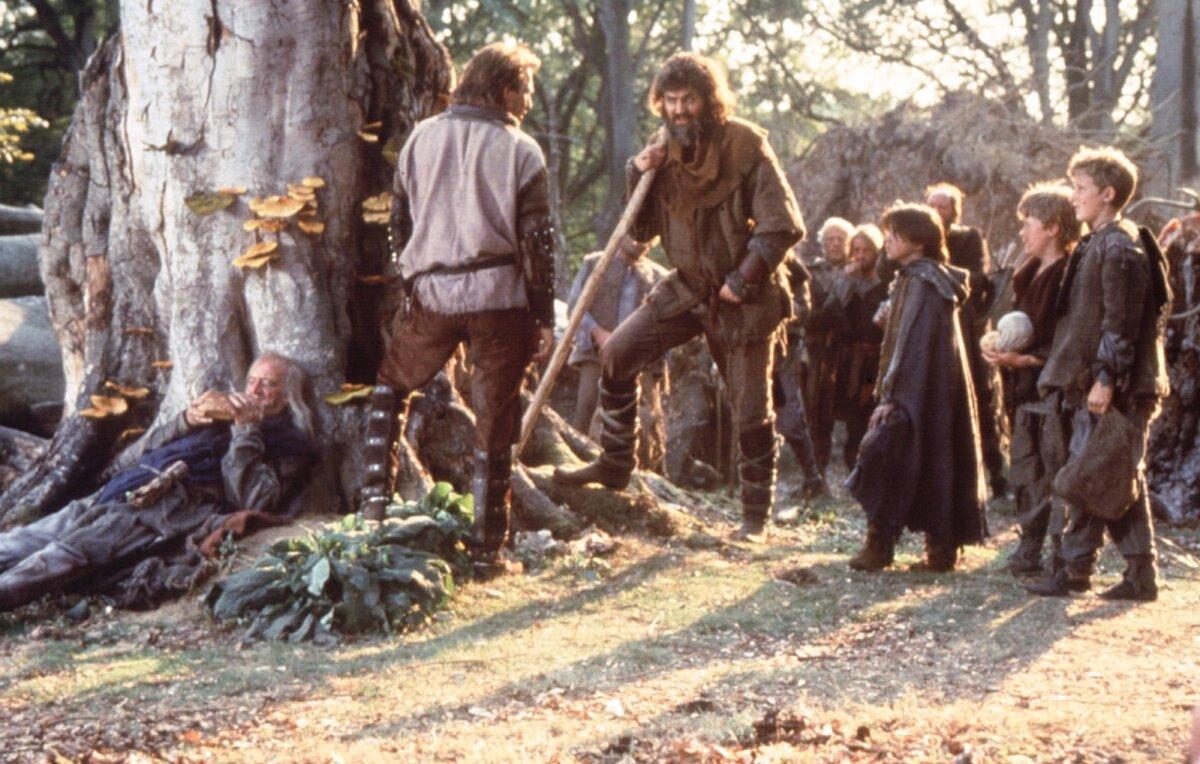 Robin Hood (Kevin Costner, L) takes his place with Little John (Nick Brimble) and the common people, who have taken refuge in Sherwood Forest, in “Robin Hood: Prince of Thieves.” (MovieStillsDB)