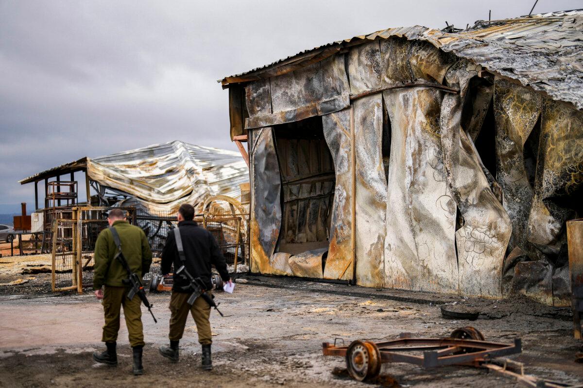 Israeli soldiers walk next to a damaged animal farm hit by a rocket fired from Lebanon in Avivim, northern Israel, near the border with Lebanon, on Nov. 27, 2024. (Francisco Seco/AP Photo)