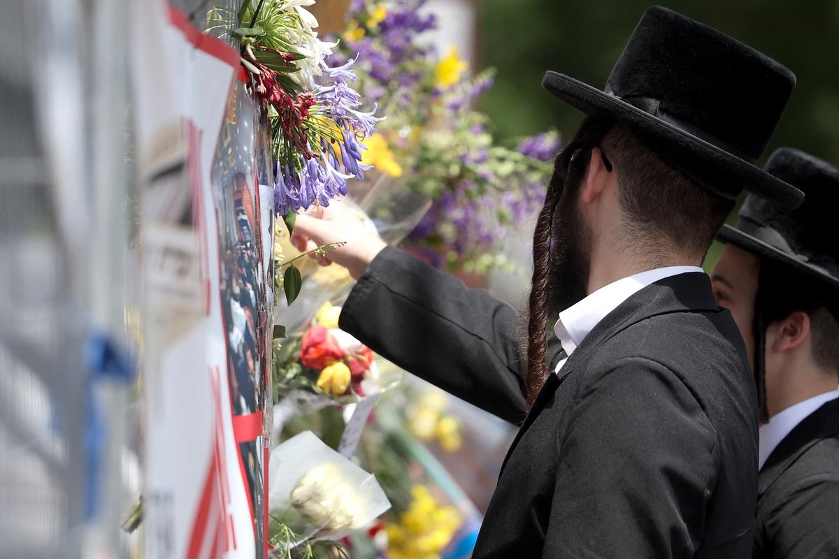 Members of the Jewish community read messages attached to the fence at the Adass Israel Synagogue in the Melbourne suburb of Ripponlea in Australia on Dec. 9, 2024. (Martin Keep/AFP via Getty Images)