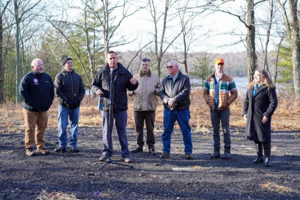 Orange County Executive Steve Neuhaus speaks in front of Boehmler Pond, along with (L to R) Orange County Legislator Tom Faggione, Outdoor Club of Port Jervis President Mike Ward, Orange County Land Trust Executive Director Jim Delaune, Deerpark Supervisor Gary Spears, Open Space Institute representative Matt Decker, and Port Jervis community development director Valerie Maginsky in the town of Deerpark, N.Y., on Dec. 18, 2024. (Cara Ding/The Epoch Times)