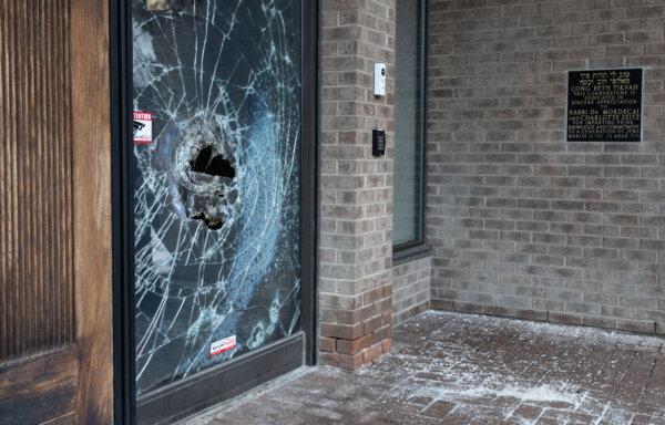 A broken window is seen on the doors of Congregation Beth Tikvah, as police investigate alleged arson at the synagogue in the suburb of Dollard-des-Ormeaux in Montreal, on Dec. 18, 2024. (The Canadian Press/Christinne Muschi)