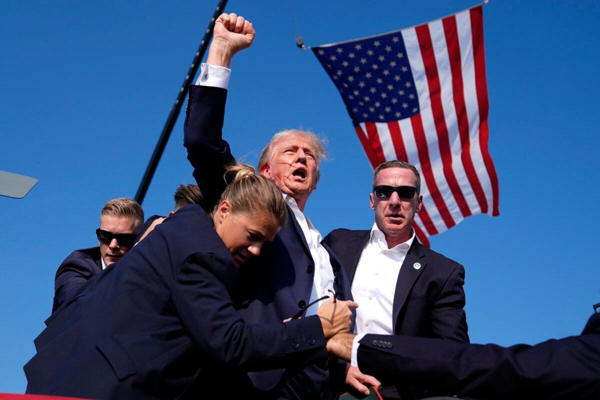 Republican presidential candidate and former President Donald Trump is surrounded by U.S. Secret Service agents at a campaign rally after an assassination attempt against Trump in Butler, Pa., on July 13, 2024. (Evan Vucci/AP Photo)