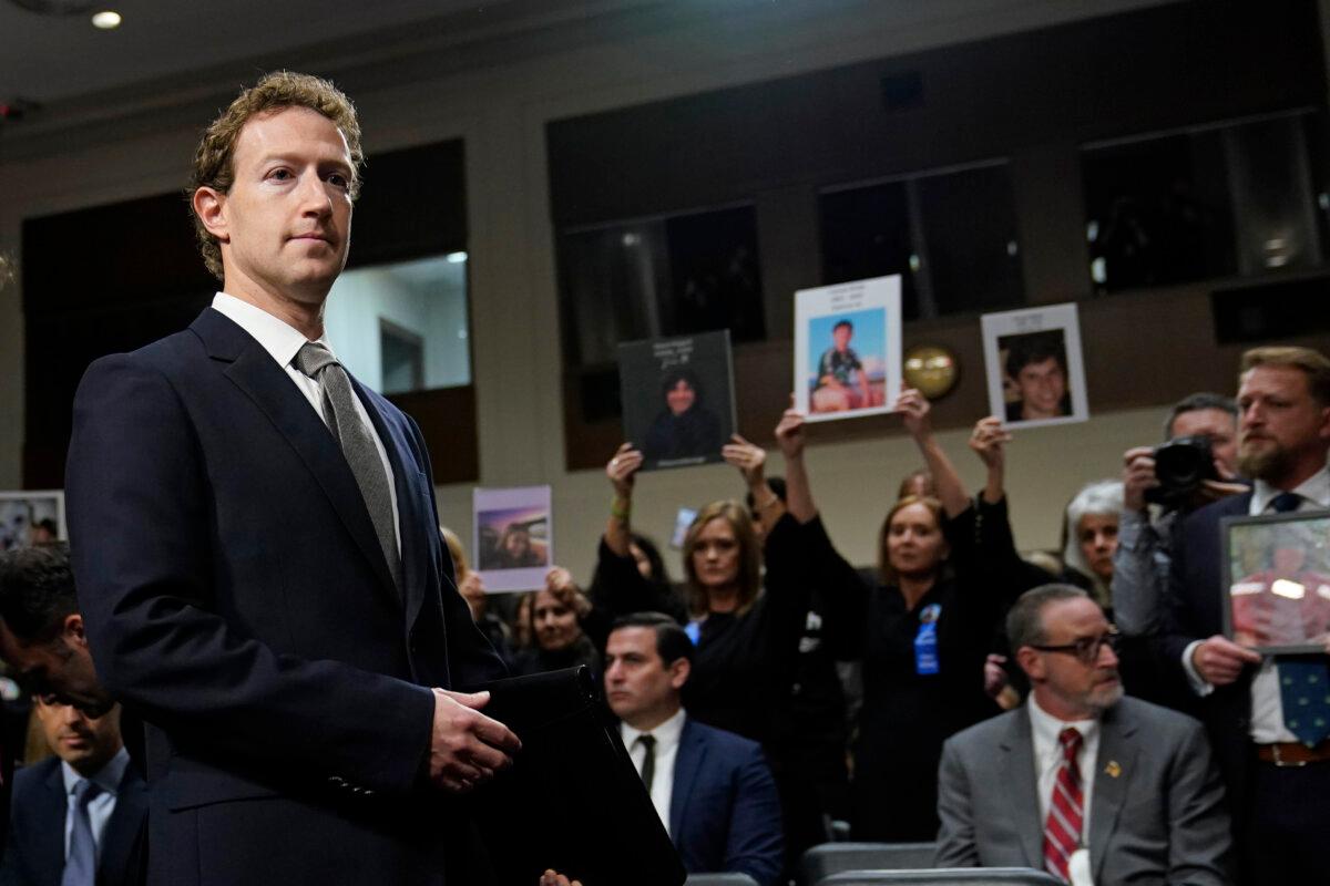 With people holding photos of their loved ones, Meta CEO Mark Zuckerberg arrives to testify before a Senate Judiciary Committee hearing on Capitol Hill in Washington on Jan. 31, 2024, to discuss child safety. (Susan Walsh/AP Photo)
