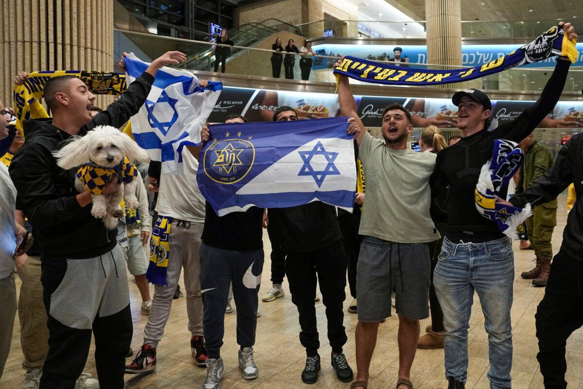 People welcome Maccabi Tel Aviv soccer fans as they arrive at Israel's Ben-Gurion International Airport on a flight from Amsterdam, where violence broke out following a match between the Israeli club and Ajax Amsterdam, on Nov. 8, 2024. (AP Photo/Tsafrir Abayov, File)