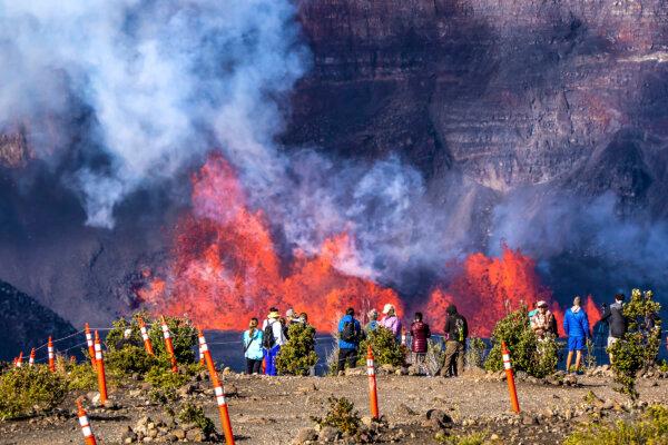 People watch as an eruption takes place on the summit of the Kilauea volcano in Hawaii on Dec. 23, 2024. (Janice Wei/NPS via AP)