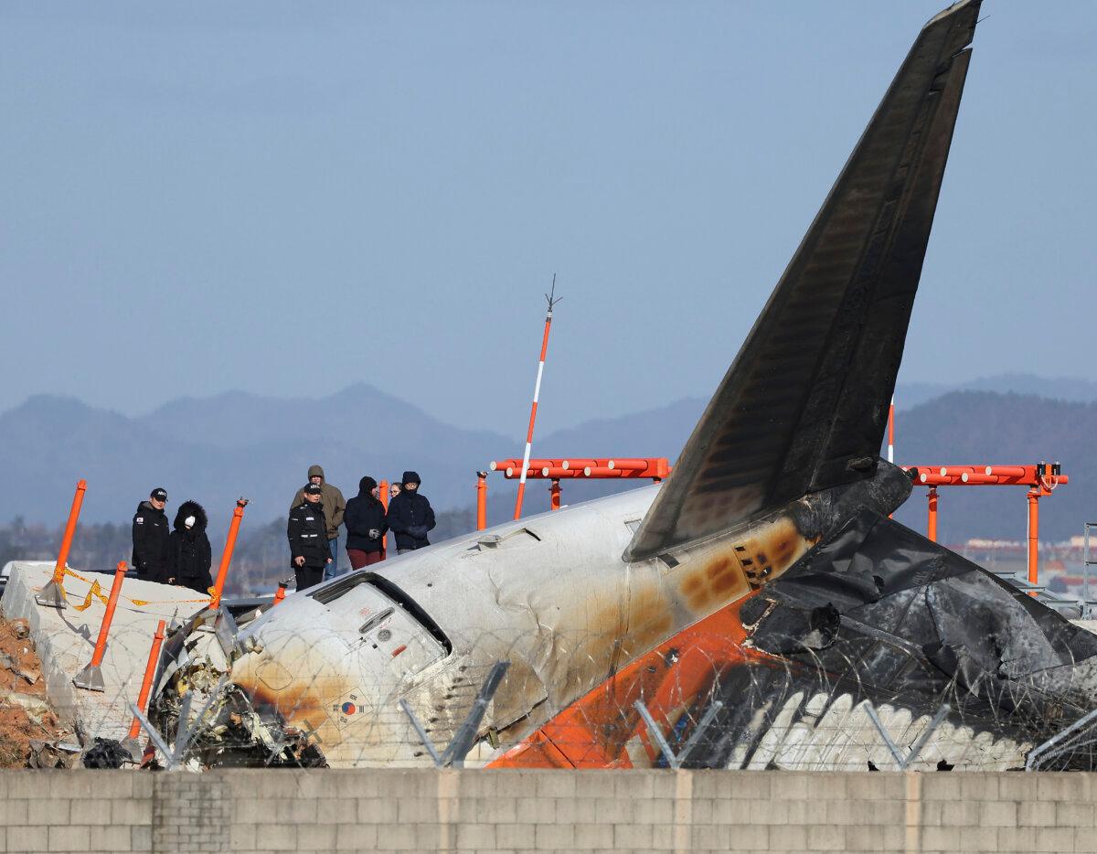 Experts from the U.S. National Transportation Safety Board (NTSB) and joint investigation team between the United States and South Korea check the site of a plane crash at Muan International Airport in Muan, South Korea, on Dec. 31, 2024. (Son Hyung-joo/Yonhap via AP)