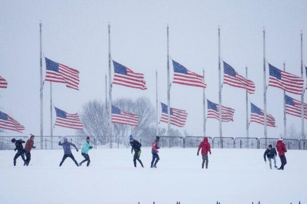 People engage in a snowball fight as U.S. flags, along the base of the Washington Monument, in Washington on Jan. 6, 2025. (Matt Rourke/AP Photo)