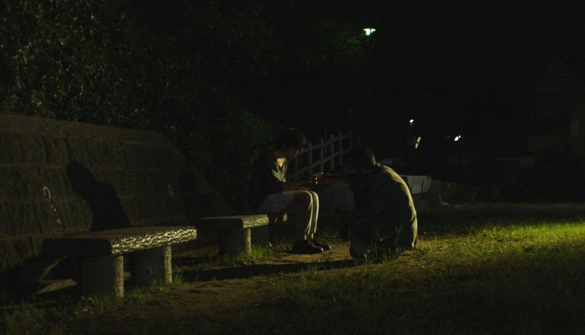 Tsuchiro (Takahiro Fujita, R), comforting Tatsumi (Yuwa Kitagaki), in “A Dobugawa Dream.” (Third Window Films)