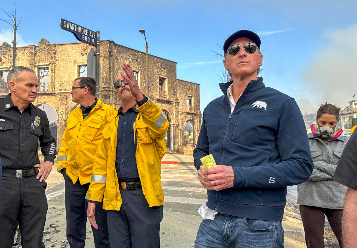 California Gov. Gavin Newsom (R) surveys damage with Cal Fire's Nick Schuler in Pacific Palisades, Calif., on Jan. 8, 2025. (Jeff Gritchen/The Orange County Register via AP)