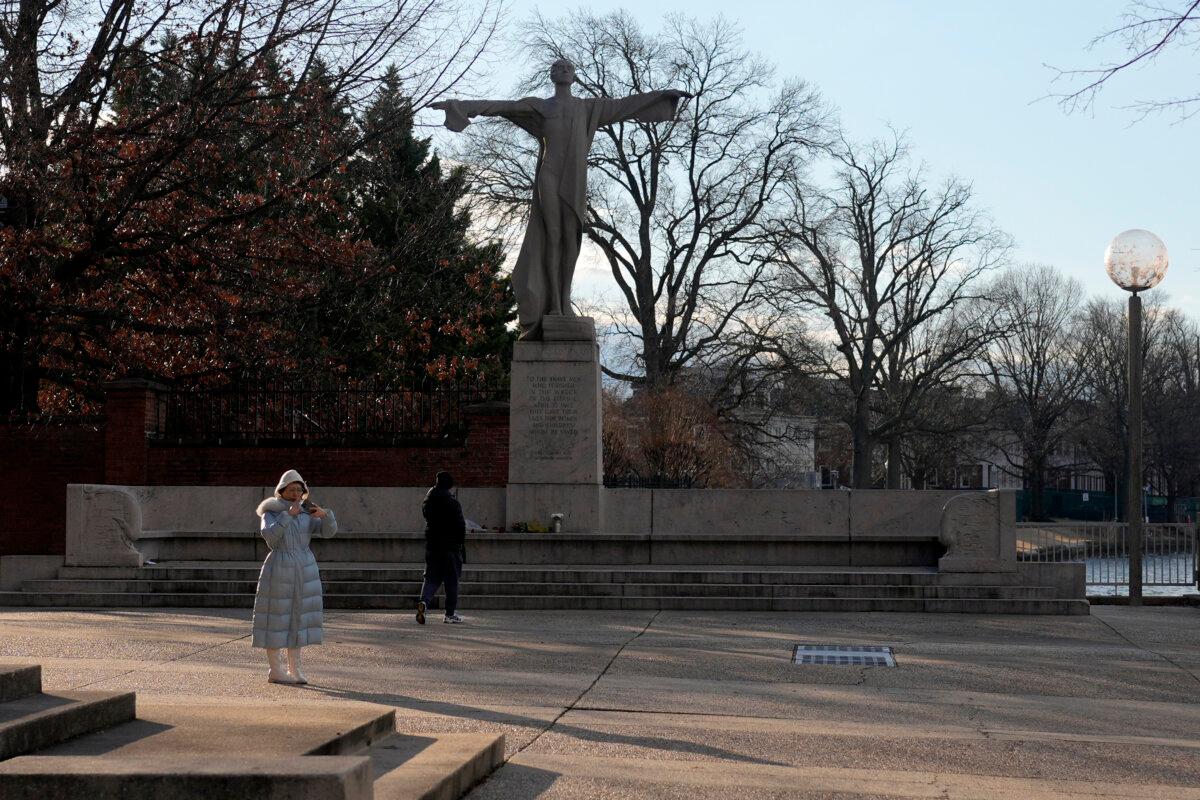 A visitor walks toward flowers and a letter left in memorial to the victims of a midair collision between an American Airlines jet and a Black Hawk helicopter near the Potomac River at the base of the Titanic Memorial in Washington, on Feb. 1, 2025. (Carolyn Kaster/AP Photo)